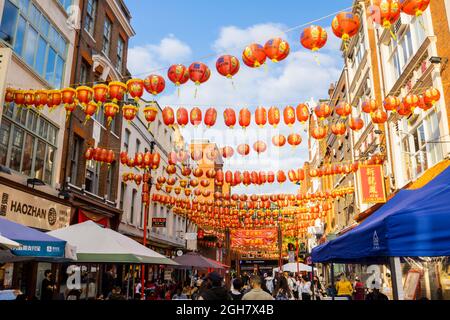 Farbenfrohe chinesische Laternen in Rot und Gold, die über die Gerrard Street in Chinatown im West End von London, W1-Bezirk der City of Westminster, aufgereiht sind Stockfoto