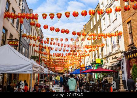 Farbenfrohe chinesische Laternen in Rot und Gold, die über die Gerrard Street in Chinatown im West End von London, W1-Bezirk der City of Westminster, aufgereiht sind Stockfoto