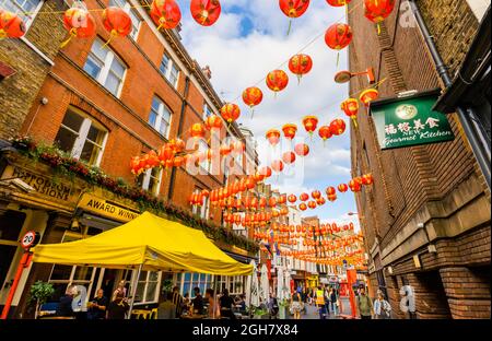 Farbenfrohe chinesische Laternen in Rot und Gold, die über die Lisle Street in Chinatown im West End von London, W1-Bezirk der City of Westminster, aufgereiht sind Stockfoto