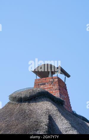 Traditionelles friesisches Strohdach und Kamin vor blauem Himmel. Stockfoto