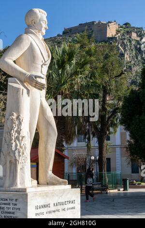 Eine Statue von Ioannis Kapodistrias, dem ersten Staatsoberhaupt des unabhängigen Griechenlands, mit der Festung Palamidhi im Hintergrund, Nafplio, Argolid, P Stockfoto