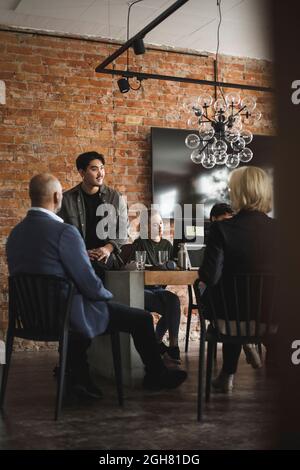 Männliche und weibliche Unternehmer sitzen im Kreativbüro Stockfoto