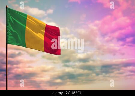 Flatterndes Mali-Flag-Mockup mit dem Platz für Ihren Text auf bunt bewölktem Himmel Hintergrund. Stockfoto