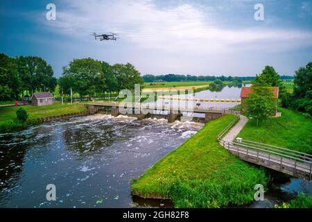 Wasser wirbelt vom Wehr im Fluss Vecht in den Niederlanden. Flussabwärts, Lock Keeper's House neben der Brücke. Fischpassage, Fischleiter zum Stockfoto