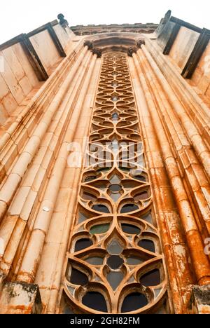 Schönes geschnitztes Fensterdekor der gotischen mittelalterlichen Kirche mit langem Perspektivwinkel von unten - Vertikal, selektiver Fokus Stockfoto