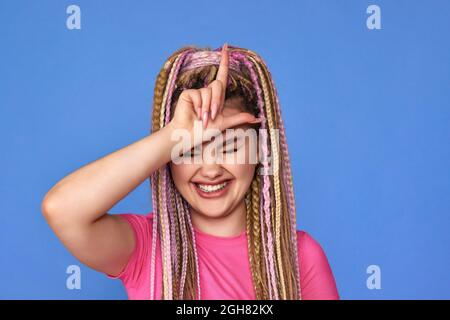 Junge Frau mit Dreadlocks Spaß auf blauem Hintergrund. Stockfoto