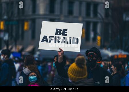 Ein Mann hält das Schild „seid besorgt“ bei einem Stop-Asian-Hassprotest in Vancouver, Kanada Stockfoto