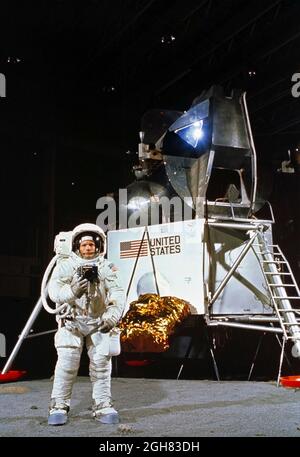 (22. April 1969) --- Astronaut Neil A. Armstrong, der eine Extravehicular Mobility Unit trägt, nimmt an einer Simulation des Einsatzes und der Verwendung von Mondwerkzeugen auf der Oberfläche des Mondes während einer Trainingsübung in Gebäude 9 am 22. April 1969 Teil. Armstrong ist der Kommandant der Mondlandemission Apollo 11. Im Hintergrund ist ein Mondlandefähre-Modell zu sehen Stockfoto