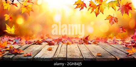 Herbsttisch - Herbstblätter Fallen Auf Holzplanke Stockfoto