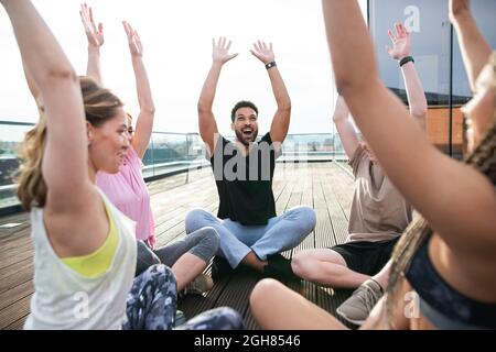 Gruppe junger Menschen, die auf der Terrasse Sport treiben, Sport und gesundes Lifestyle-Konzept. Stockfoto