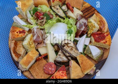 Typisches Essen von Apulien. Focaccia, Mozzarella, Oliven, Tomaten, gegrilltes Gemüse, Salami und Käse Stockfoto
