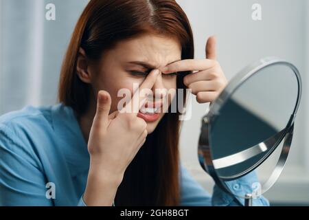 Frau sitzt am Tisch vor dem Spiegel Frisur Pflege Stockfoto