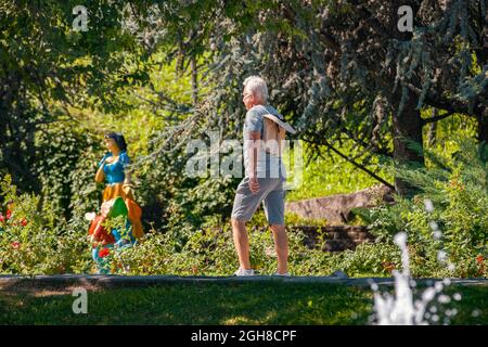 Ankara, Türkei - 02. September 2021: Älterer Mann, der an einem sonnigen Morgen im Park spazieren geht. Aktiver alter Mann, der im Dikmen Valley Park in Ankara Sport macht. Stockfoto