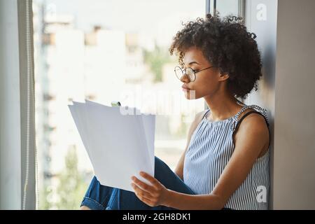 Junge, ernste, schöne, lockige Hündin mit Dokumenten Stockfoto