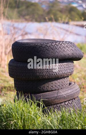 Ein Stapel alter gebrauchter Reifen, die auf dem Land aufgegeben wurden Stockfoto