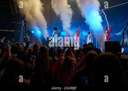 Kiew, Ukraine 3. September 2021: Rückansicht der Menge mit ausgestreckten Armen beim Konzert. Jubelnde Menge beim Rockkonzert. Silhouetten der Konzertmenge Stockfoto