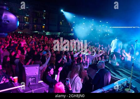 Kiew, Ukraine 3. September 2021: Rückansicht der Menge mit ausgestreckten Armen beim Konzert. Jubelnde Menge beim Rockkonzert. Silhouetten der Konzertmenge Stockfoto