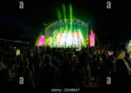 Kiew, Ukraine 3. September 2021: Rückansicht der Menge mit ausgestreckten Armen beim Konzert. Jubelnde Menge beim Rockkonzert. Silhouetten der Konzertmenge Stockfoto