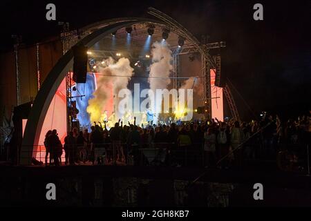 Kiew, Ukraine 3. September 2021: Rückansicht der Menge mit ausgestreckten Armen beim Konzert. Jubelnde Menge beim Rockkonzert. Silhouetten der Konzertmenge Stockfoto