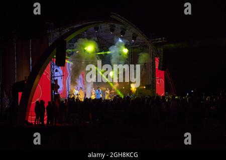 Kiew, Ukraine 3. September 2021: Rückansicht der Menge mit ausgestreckten Armen beim Konzert. Jubelnde Menge beim Rockkonzert. Silhouetten der Konzertmenge Stockfoto