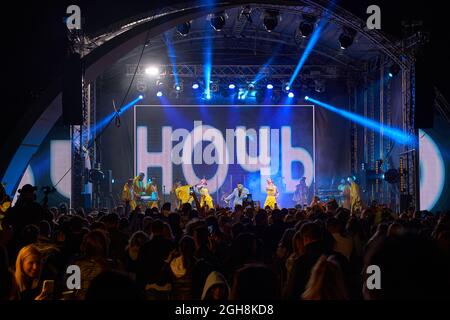 Kiew, Ukraine 3. September 2021: Rückansicht der Menge mit ausgestreckten Armen beim Konzert. Jubelnde Menge beim Rockkonzert. Silhouetten der Konzertmenge Stockfoto