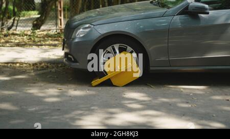 Ein geparktes Auto mit einem gelben Reifenschloss wegen der illegalen Parkverletzung. Sperrbereich für Räder zum Parken. Stockfoto