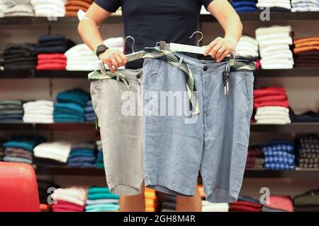 Der sportliche Mann wählt neue Shorts für die Nahaufnahme im Sommer Stockfoto