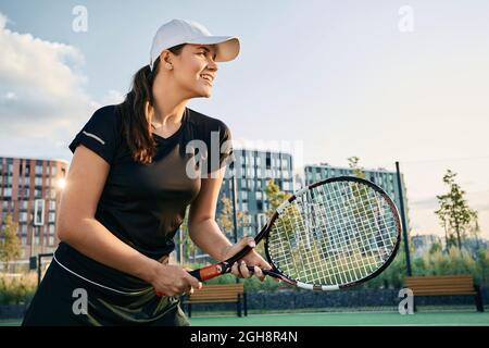 Brünette weibliche Tennisspielerin mit Tennisschläger, während Tennis-Spiel in Bewegung Stockfoto