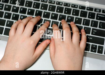 Online-Schulung. Kinder haben die Laptop-Tastatur in der Hand. Nahaufnahme. Computerkenntnisse und -Technik im Kinderleben, Kindertastatur, Training fas Stockfoto