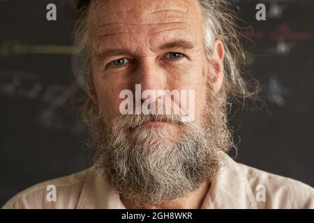 Porträt eines Mannes mittleren Alters mit Bart und grauen Haaren. Der Mann hat ein ernsthaftes Gesicht und einen intensiven Blick. Stockfoto
