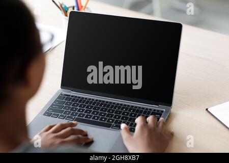 Teen afro american schulmädchen in Brille tippen auf Laptop Stockfoto