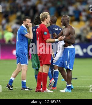 Der Italiener Mario Balotelli scherzt mit dem Engländer Joe Hart beim Schlusspfiff während des Viertelfinales zwischen England und Italien im Olympiastadion in Kiew am 24. Juni 2012. Stockfoto