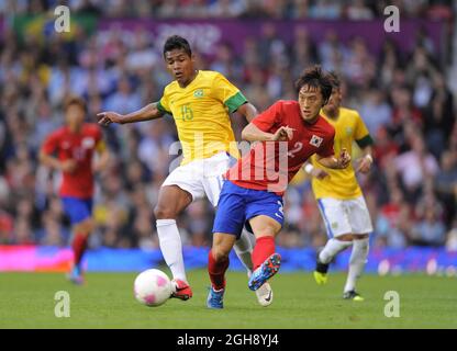 Der Brasilianer Alex Sandro tötelt mit dem südkoreanischen Oh Jae-suk.Südkorea gegen Brasilien Olympisches Halbfinalspiel 2012 in Old Trafford, Manchester, Großbritannien am 7. August 2012. Stockfoto