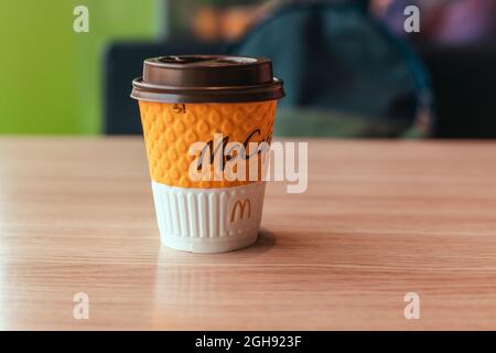 Odessa, Ukraine - März 05 2021: Papiertasse von McDonald's Coffee auf Holztisch in einem Café Stockfoto