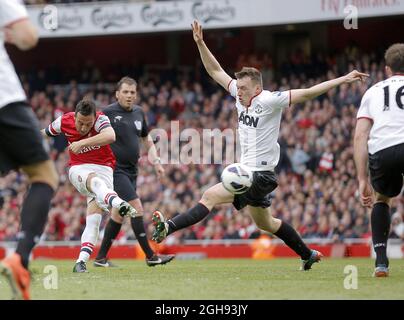 Santi Cazorla von Arsenal schießt am 28. April 2013 im Emirates Stadium, London, vor Phil Jones von Manchester United beim Spiel der Barclays Premier League zwischen Arsenal und Manchester United auf das Tor. Stockfoto