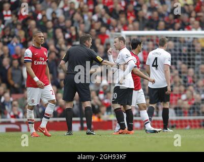 Mit Wayne Rooney von Manchester United spricht Schiedsrichter Phil Dowd während des Spiels der Barclays Premier League zwischen Arsenal und Manchester United im Emirates Stadium, London, am 28. April 2013. Stockfoto