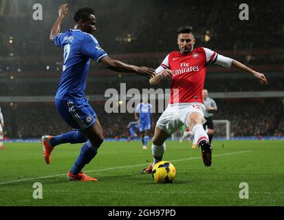 Olivier Giroud von Arsenal tünchelt mit John Mikel Obi von Chelsea während des Spiels der Barclays Premier League zwischen Arsenal und Chelsea im Emirates Stadium in London, Großbritannien, am 23. Dezember 2013. Pic David Klein Stockfoto