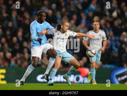 Yaya Toure von Manchester City tritt Joe Cole von West Ham United während des Capital One Cup Halbfinals mit der 1. Etappe zwischen Manchester City und West Ham Utd an, das am 8. Januar 2014 im Etihad Stadium in Manchester, England, stattfand. Stockfoto