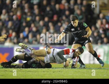 Jared Payne von Ulster wird am 18. Januar 2014 im Welford Road Stadium in Leicester, England, vor Ben Youngs von Leicester Tigers während des Heineken Cup, Runde 6, Pool 5-Match zwischen Leicester Tigers und Ulster in Angriff genommen. Stockfoto