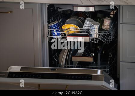 Nahaufnahme eines Spülers mit mehreren Tassen und Shishes im Inneren in einer modernen Luxusküche Stockfoto