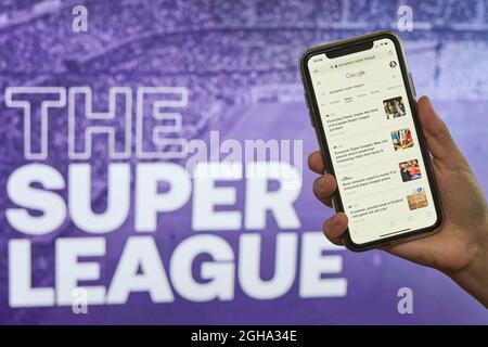 Taschkent, Usbekistan - 27. April 2021: Hand hält ein Smartphone mit Nachrichten-Website über dem Super League-Logo. Jährliche Club-Fußball-Wettbewerb, dass Stockfoto