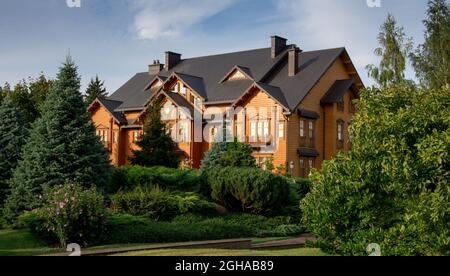 Großes, schönes Holzhaus, umgeben von grünen Bäumen Stockfoto