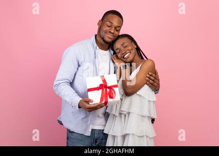 Glücklicher schwarzer Mann macht Überraschung für Frau geben Box Stockfoto