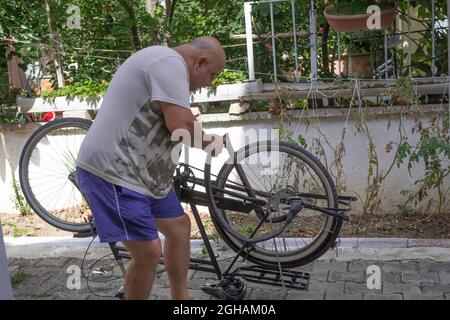 Fat Mann Befestigung Väter das Fahrrad, um ihn glücklich zu machen. Hart arbeitend Sohn versucht, seinen Vater stolz zu machen. Stockfoto
