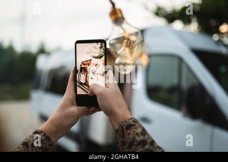 Verkürzte Hände eines Mannes, der im Urlaub eine Frau auf einem Smartphone fotografiert Stockfoto