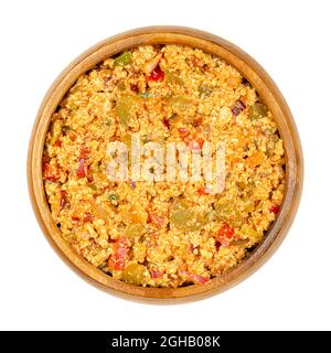 Vegane Liptauer Brotaufstrich, in einer Holzschale. Würziger Aufstrich aus zerbröckeltem weißen Tofu, roten Paprika, Gurken, Zwiebeln und Gewürzen. Stockfoto