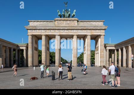Berlin, Deutschland - 31. Juli 2021: Gruppe von Menschen, Touristen am Brandenburger Tor, Wahrzeichen der Stadt, neoklassizistische Architektur Stockfoto