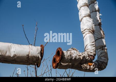 Defekte Wärmedämmung der Stadtwasserversorgung. Veraltete Technologie. Zerstörte Infrastruktur, oberirdische Wärmerohre. Stockfoto