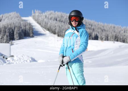 Junge Frau auf der Piste in ihrem Winterurlaub im Bergskigebiet Stockfoto