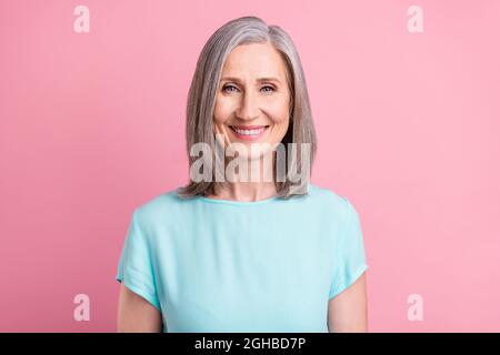 Foto von niedlichen älteren grauen Frisur Dame tragen blaue Bluse isoliert auf rosa Hintergrund Stockfoto